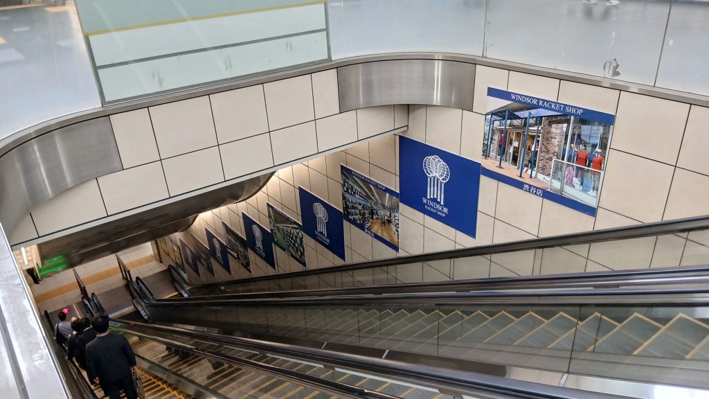 国際展示場駅のエスカレーター壁面に連続して掲出されたウインザー商事株式会社の駅広告