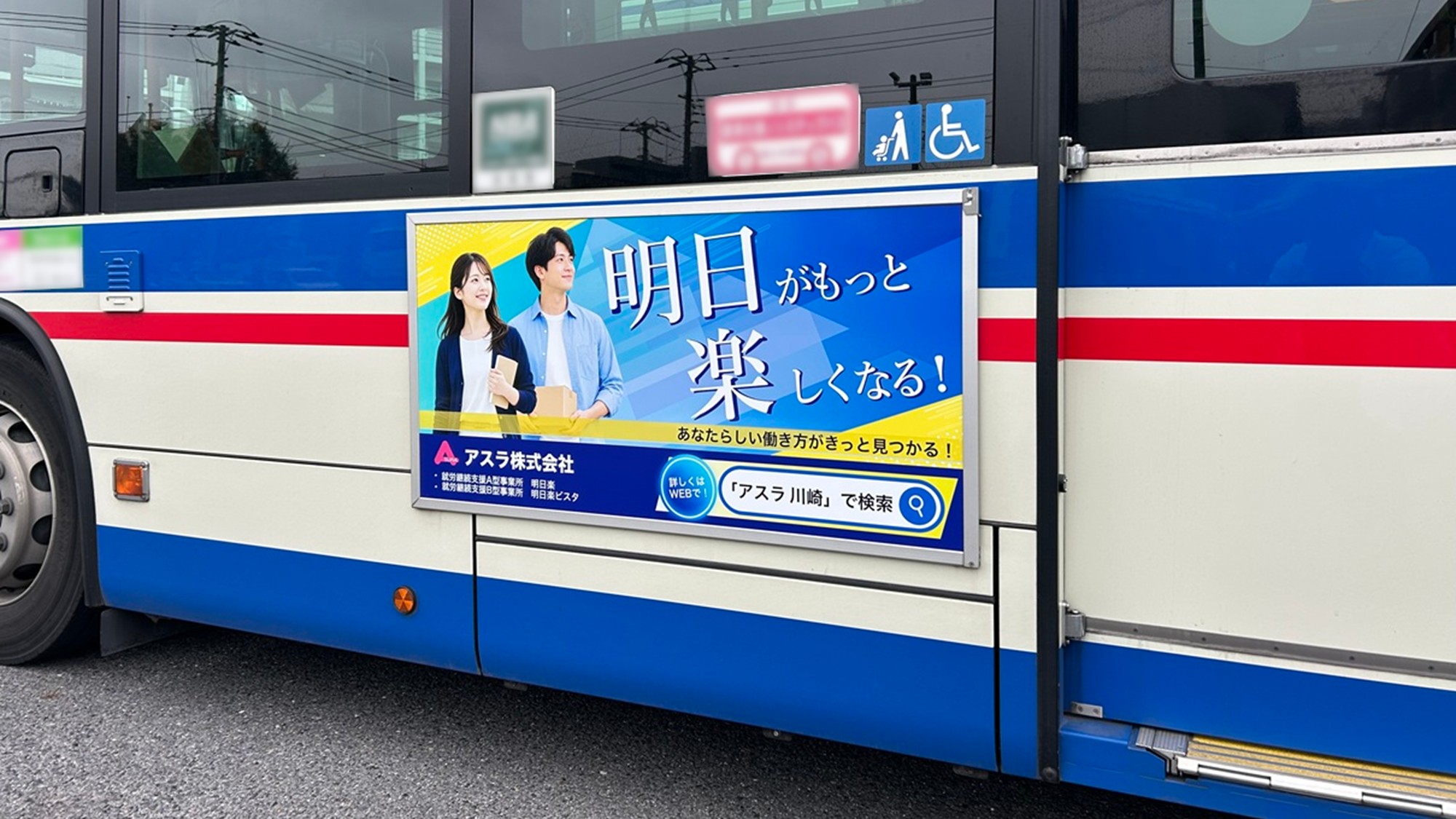 川崎鶴見臨港バスの歩道側に掲出されたアスラ株式会社の車外広告