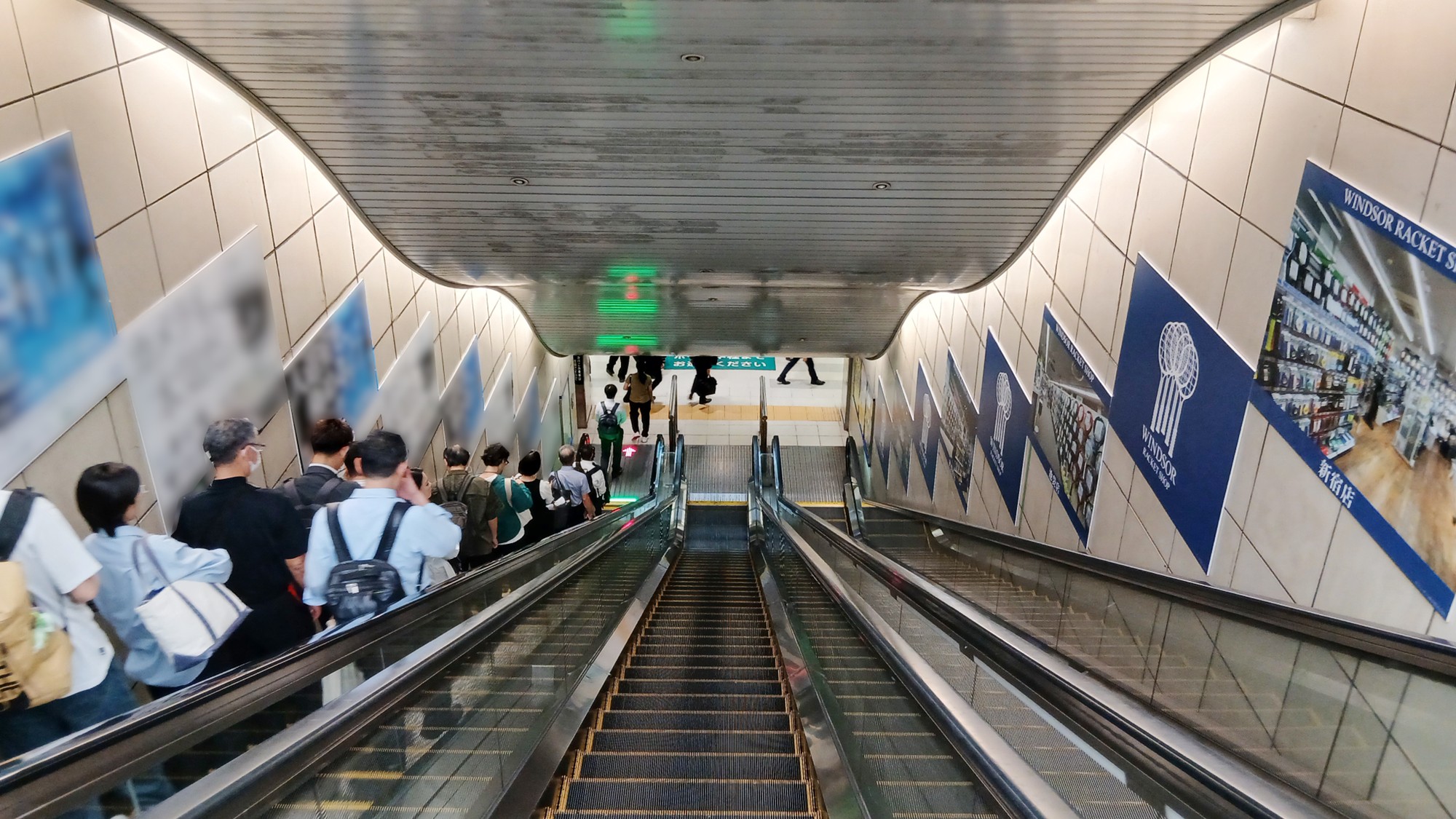 国際展示場駅のエスカレーター上部から見たウインザーラケットショップの集中貼り広告