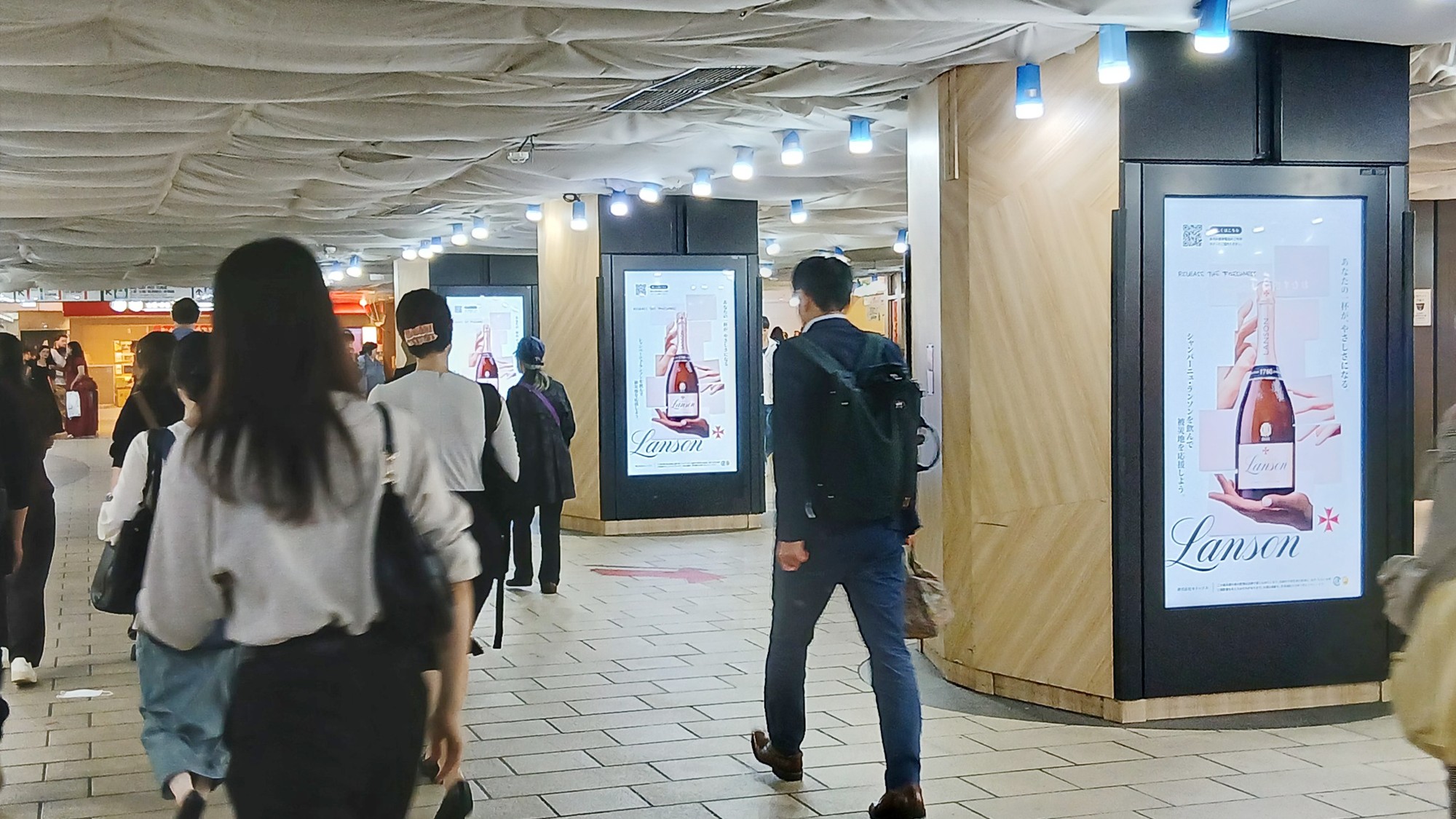 JR東京駅京葉通路の複数のJ・ADビジョンに放映されたランソン災害義援金キャンペーン2026の広告
