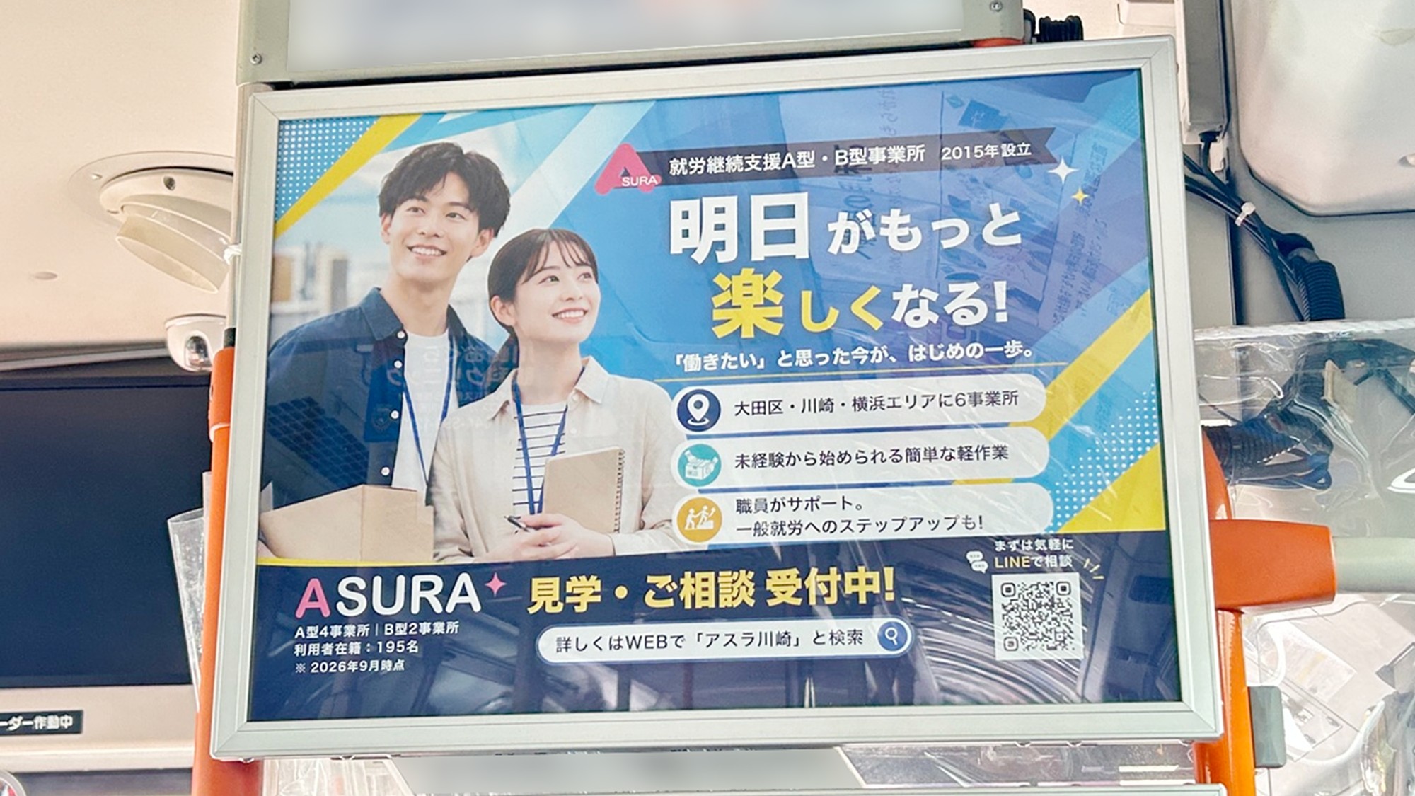 川崎鶴見臨港バスの運転席後部に掲出されたアスラ株式会社のポスター広告を近くから見た様子