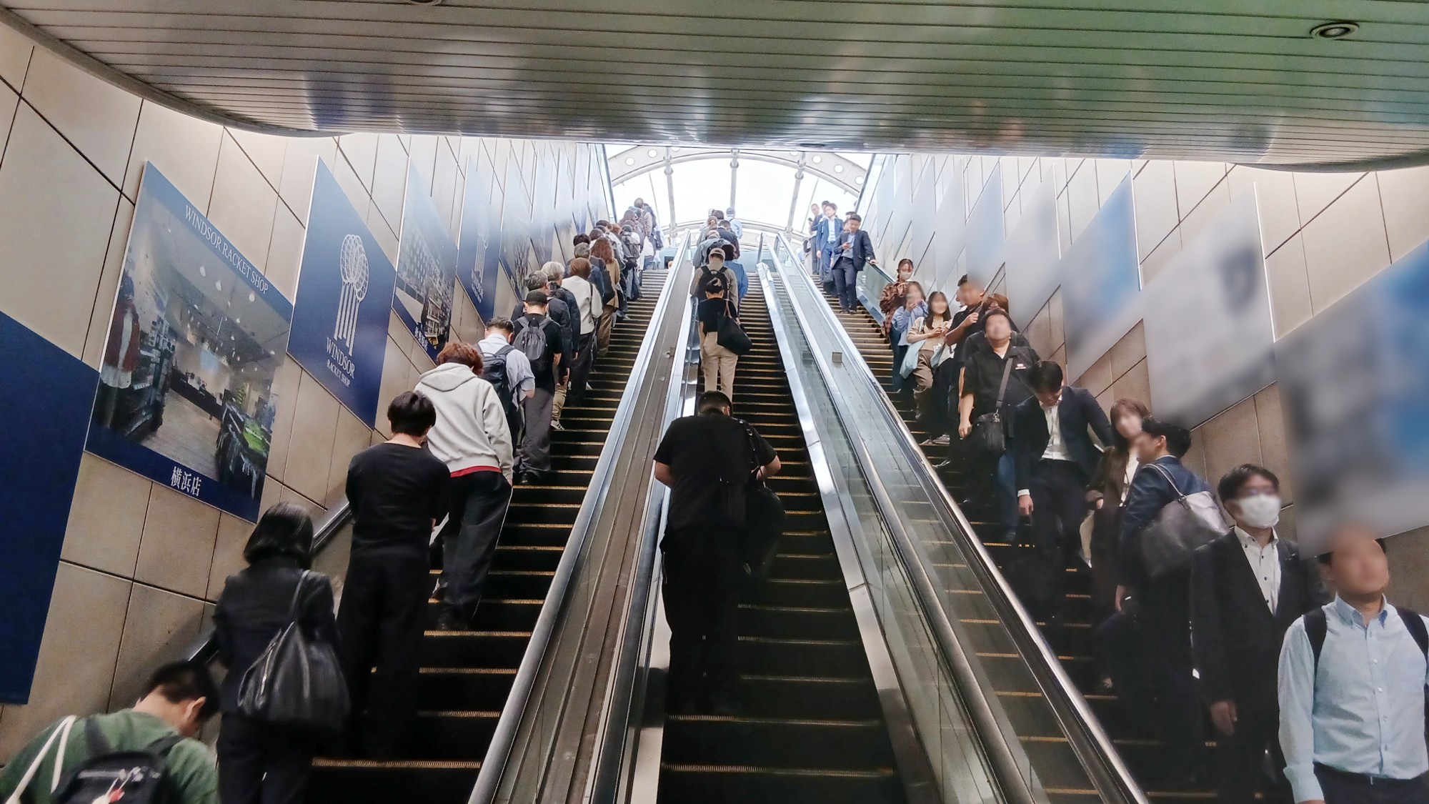 国際展示場駅のエスカレーター下部から見たウインザーラケットショップの集中貼り広告